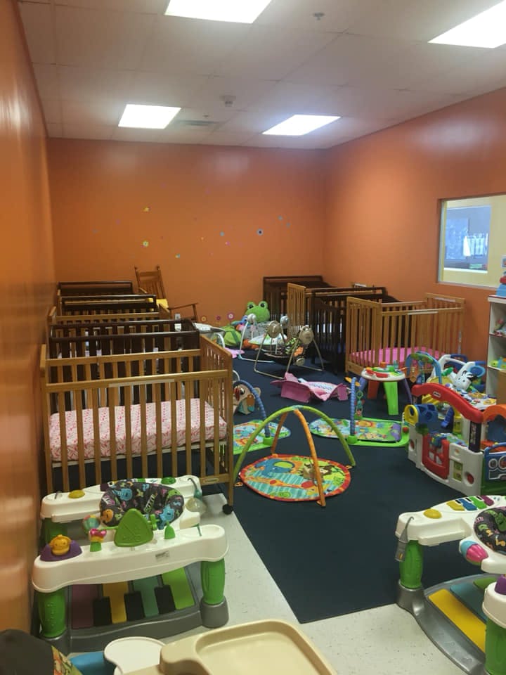 Room with multiple cribs and baby play mats