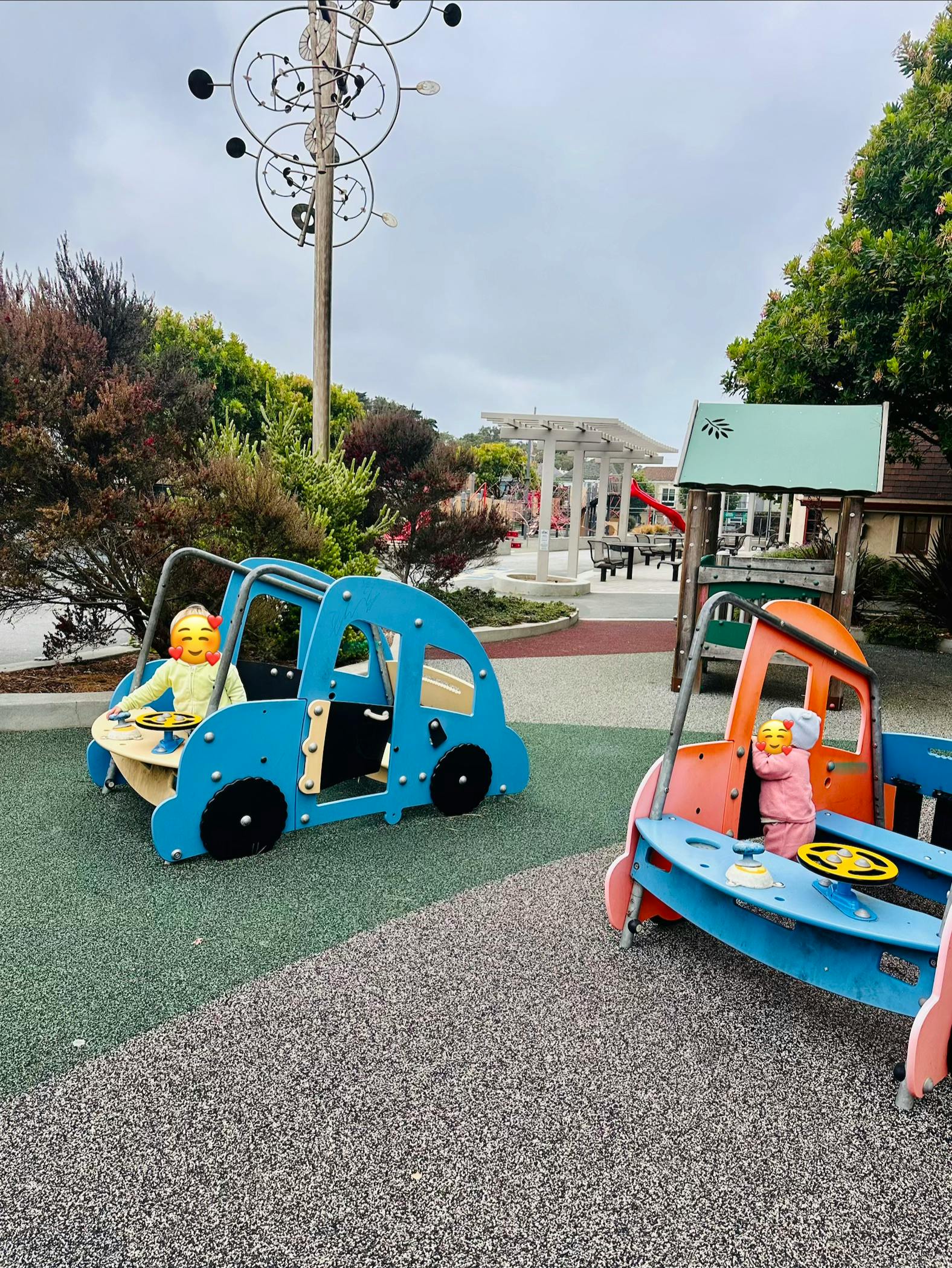 Children playing in toy car structures at a playground