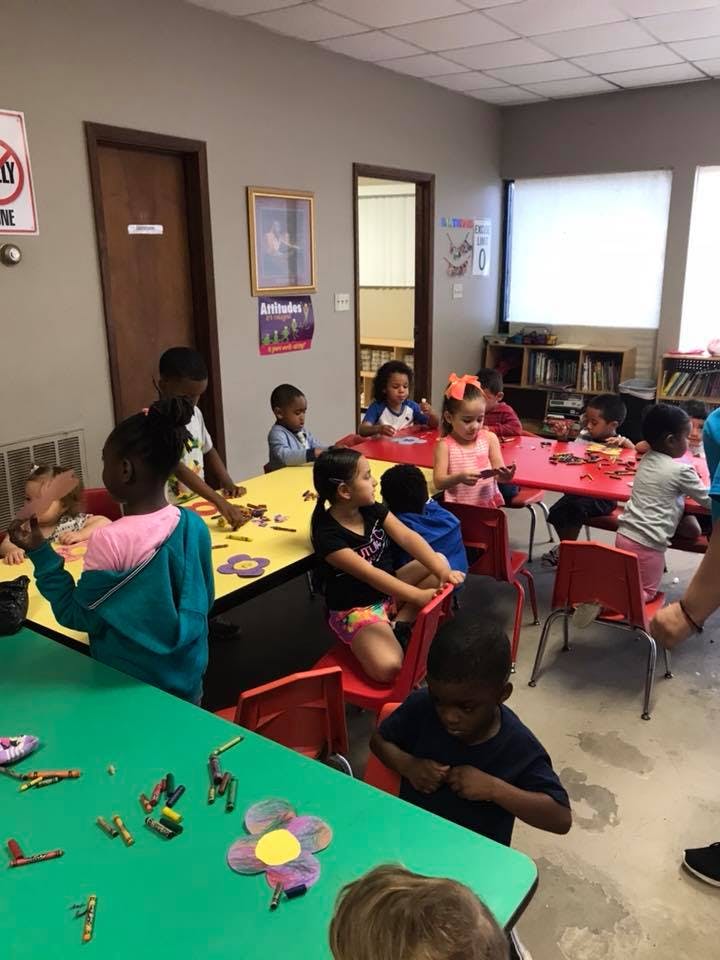 Children sitting at tables in a classroom