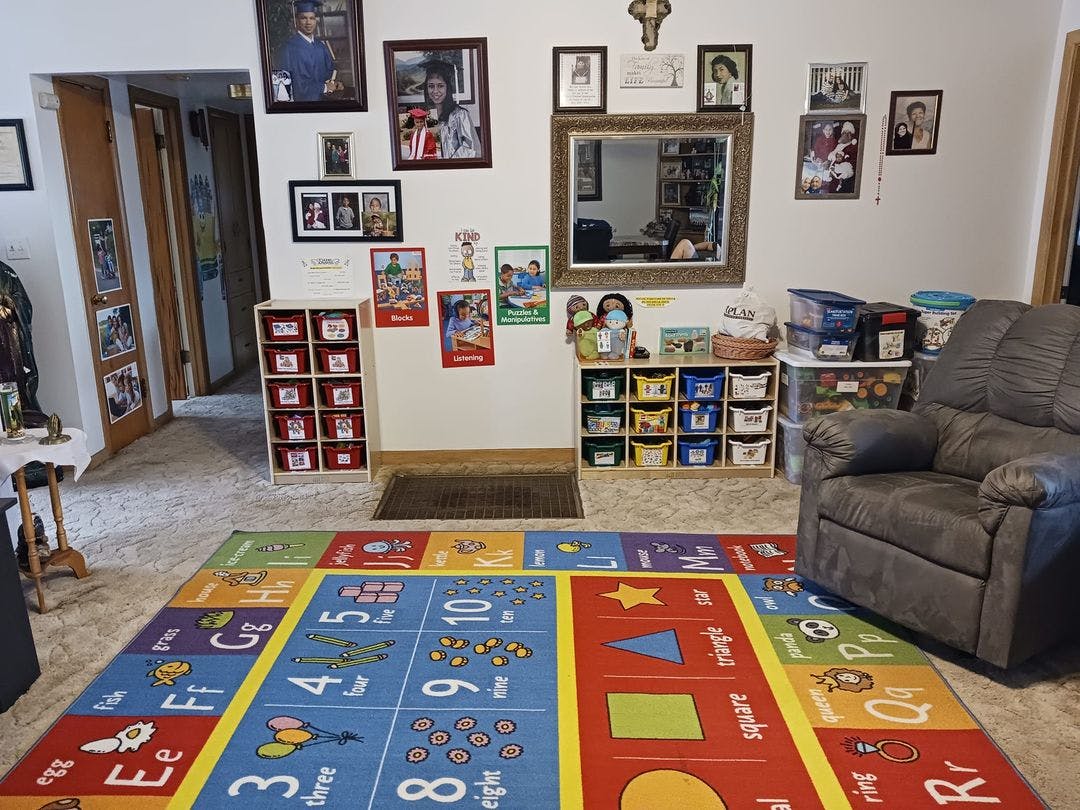 Educational playroom with children's learning rug, toy storage bins, and decor