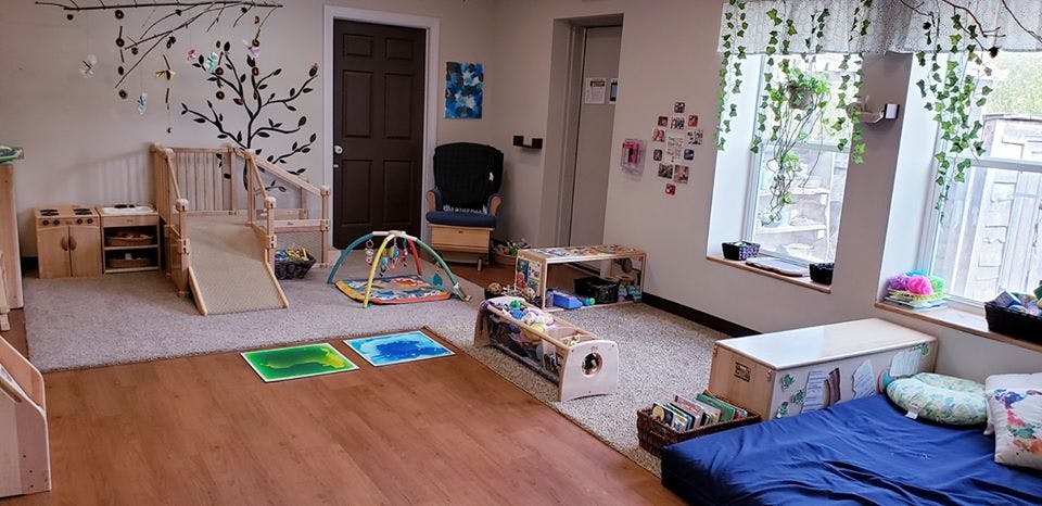 Playroom with wooden slide, play mat, and blue floor cushion