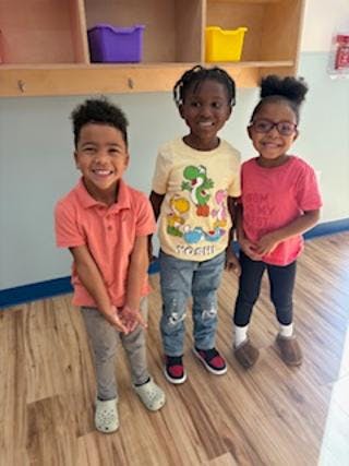 Three children standing side by side and smiling
