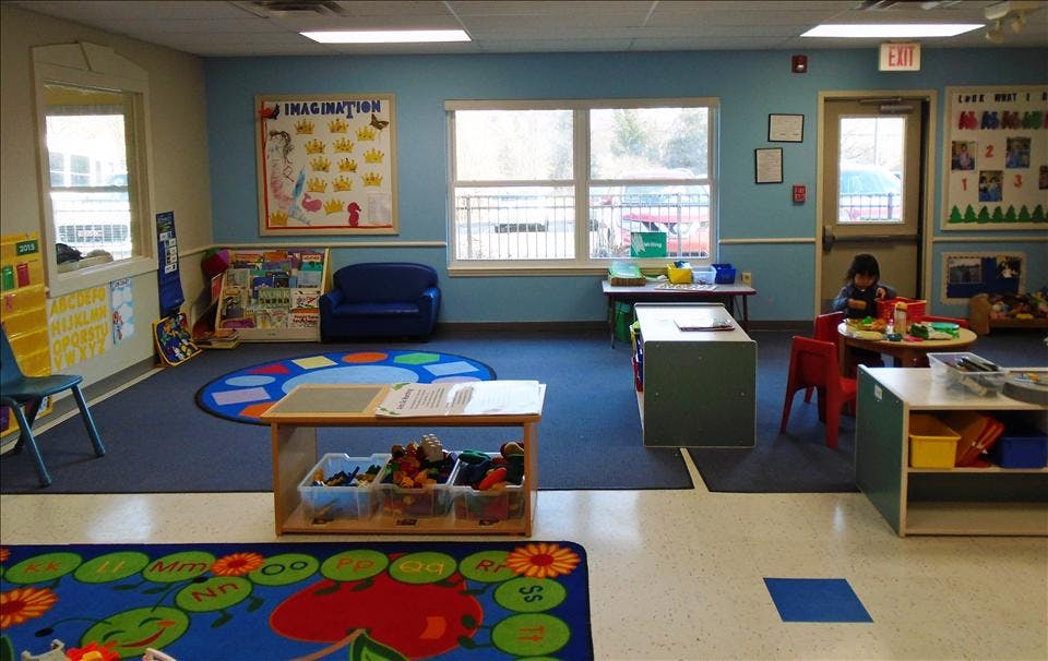 Child playing at a table in a bright classroom