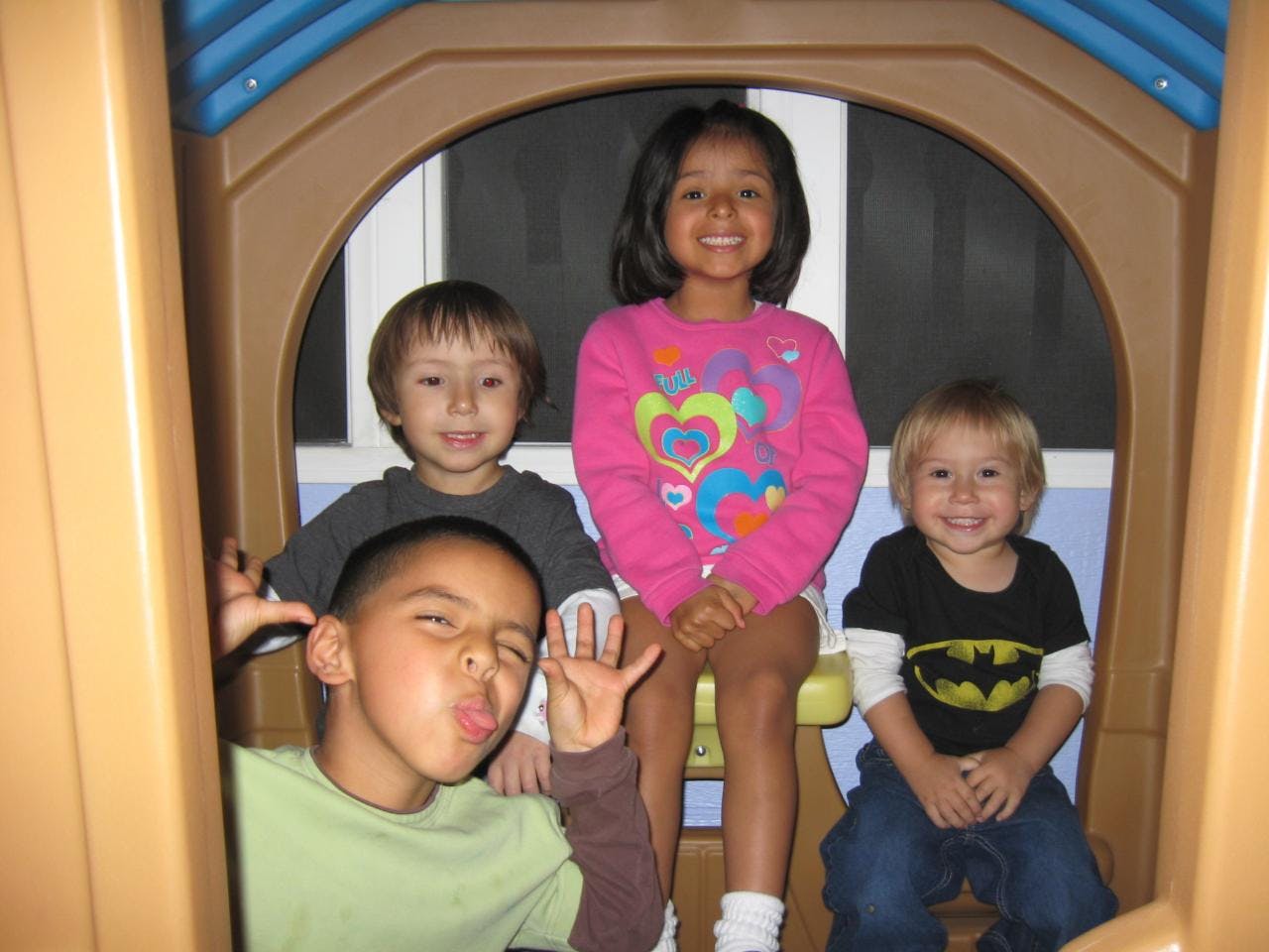 Four children posing in a play structure