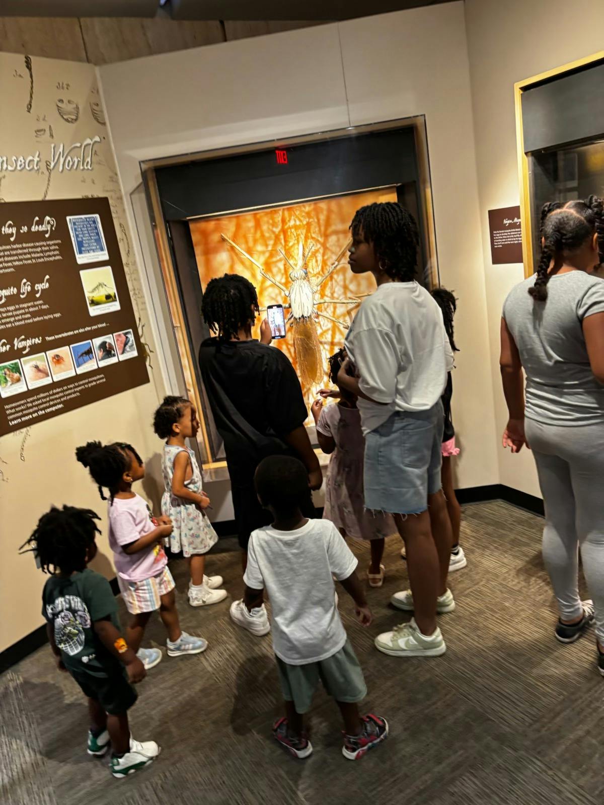 People and children looking at an exhibit in a museum