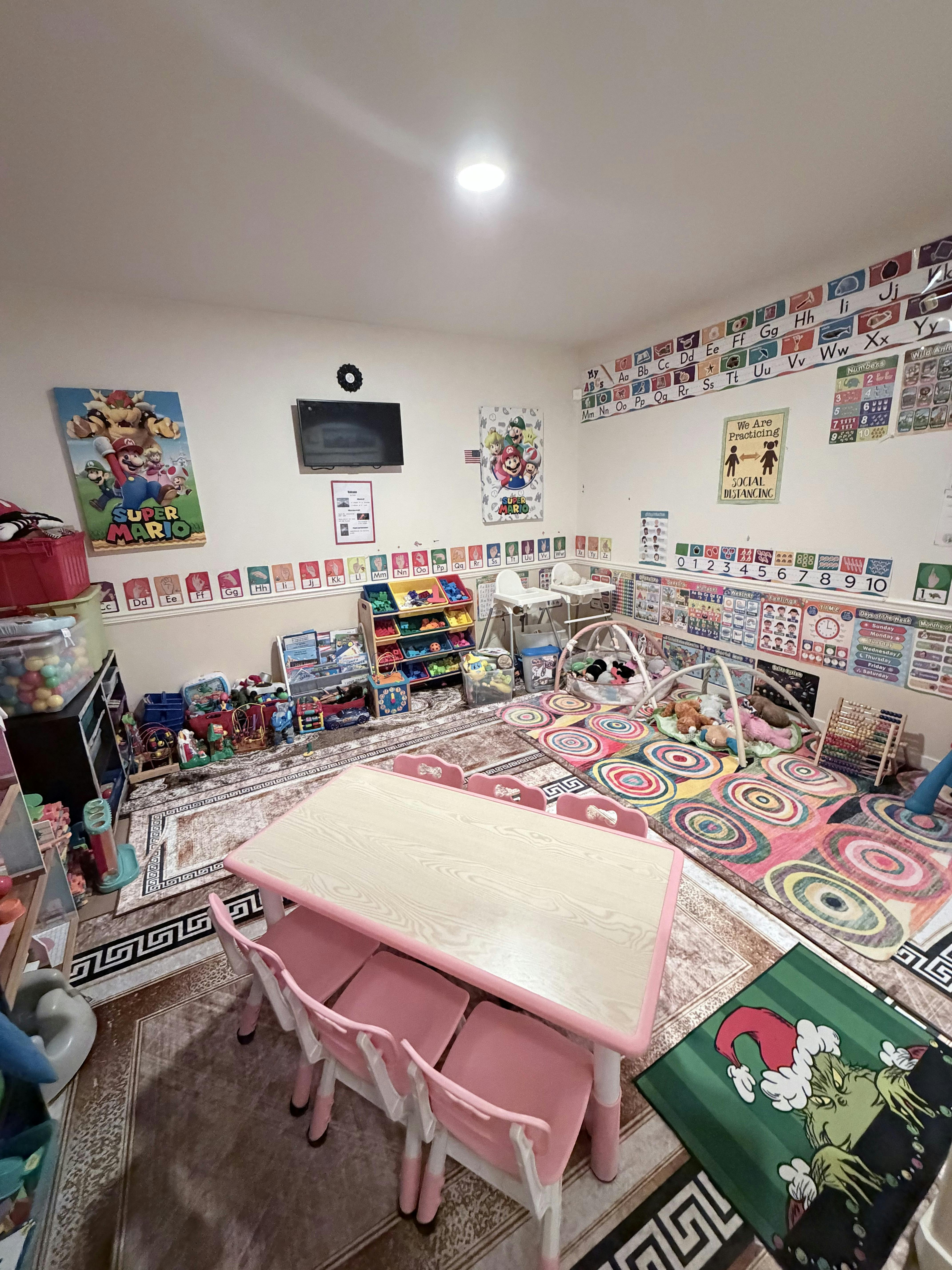 Playroom with a small table and chairs, toys, and colorful rugs