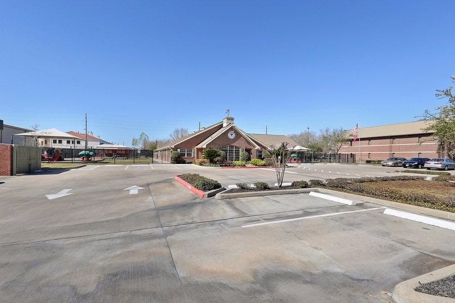 Building with a clock on the facade and a parking lot in front