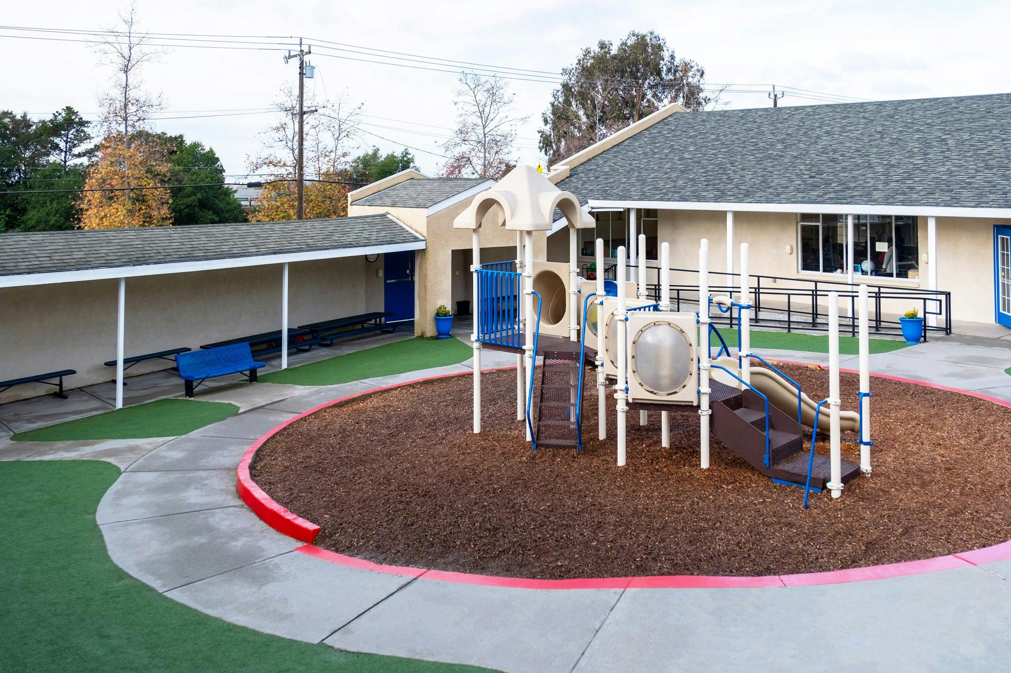 Outdoor playground with slides and climbing structures on wood chips