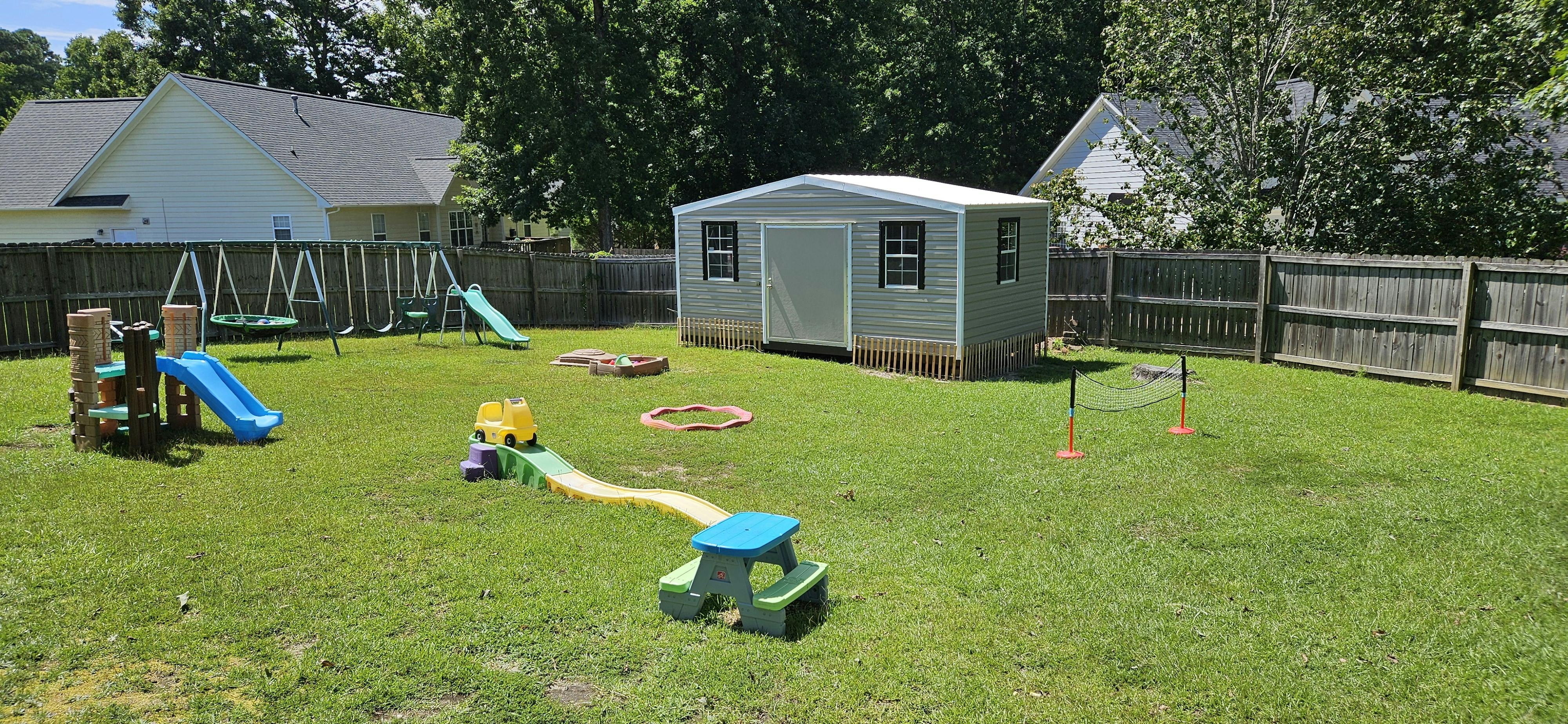 Backyard with a swing set, slide, and shed
