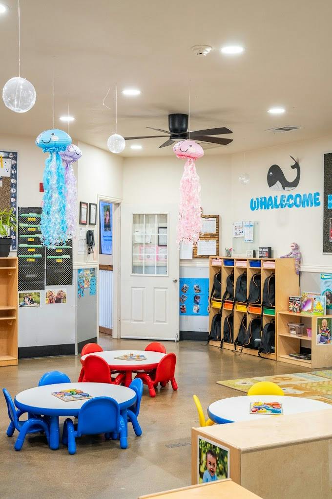 Classroom with small round tables, chairs, and hanging jellyfish decorations