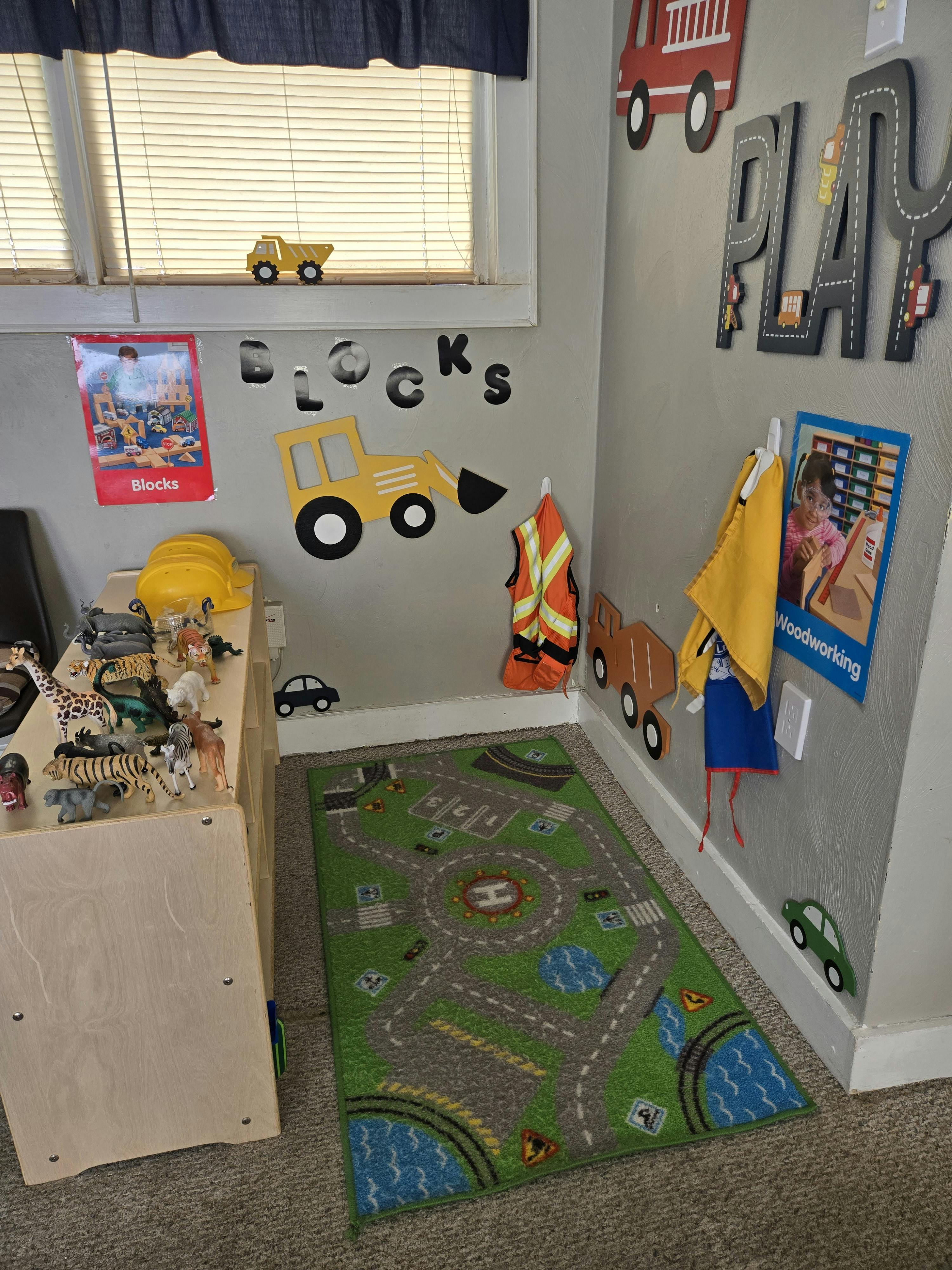 Child's room with a play rug, toy animals, and wall decorations