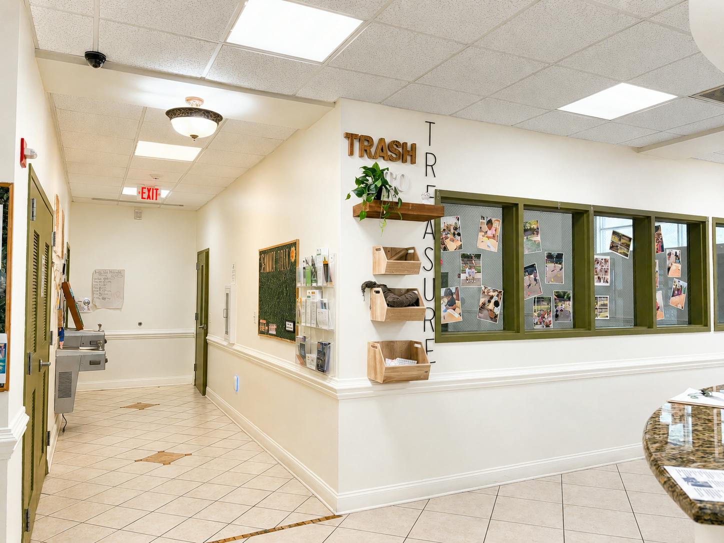 Hallway with a Trash to Treasure display wall and window featuring photos