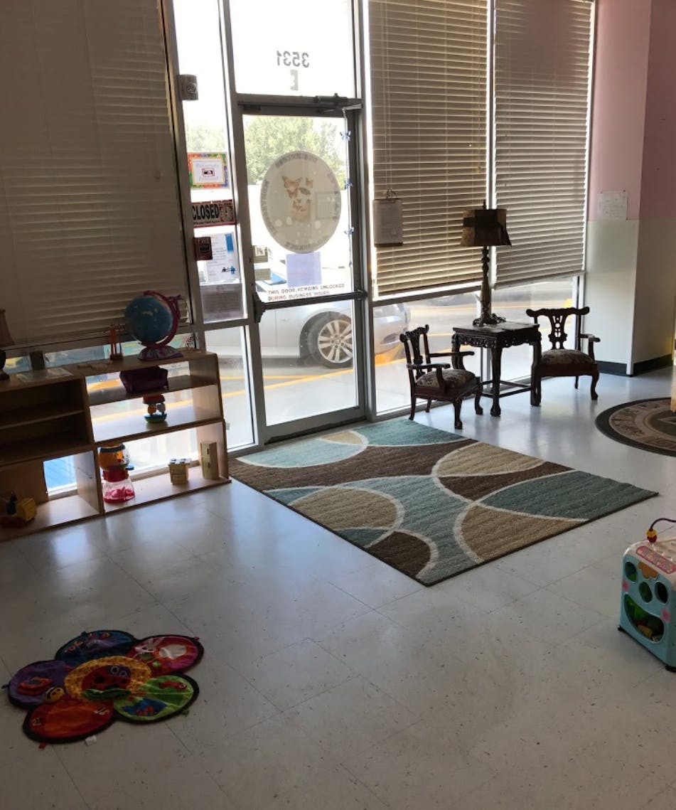 Interior room with a patterned rug, small table and chairs, and shelves