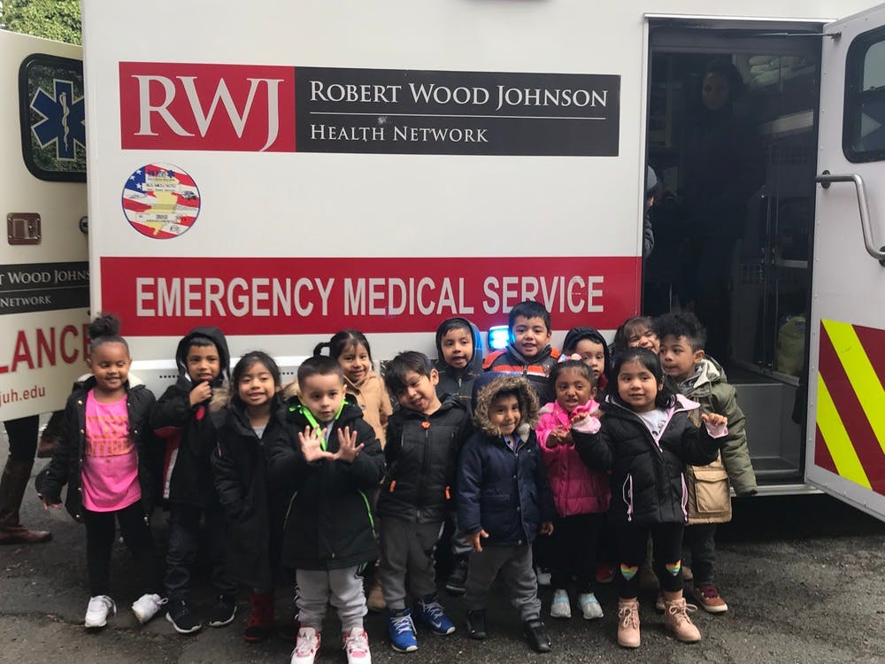 Group of children standing in front of an ambulance