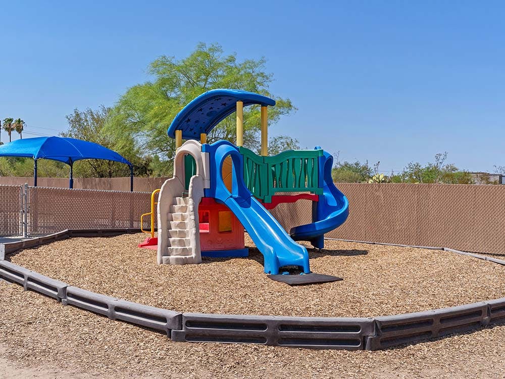 Colorful playground structure with slides on wood chips