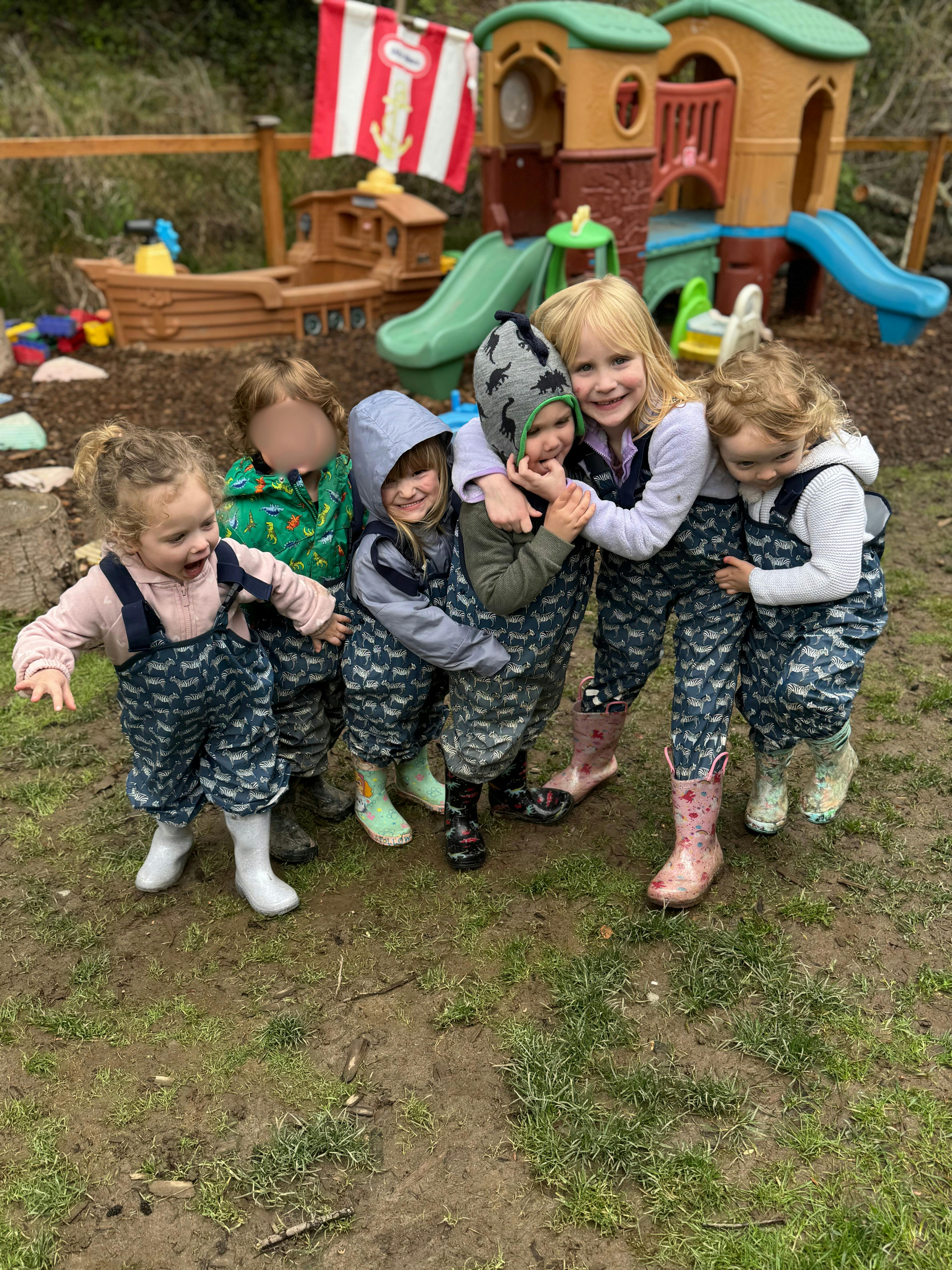 Group of children in rain gear standing together outdoors