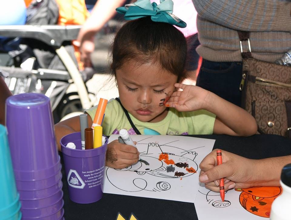 Child coloring a drawing with markers and crayons
