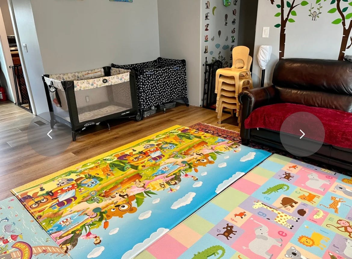 Playpen and crib in a room with colorful playmats on the floor