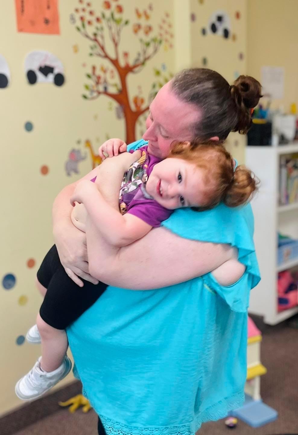 Person holding a child in a classroom