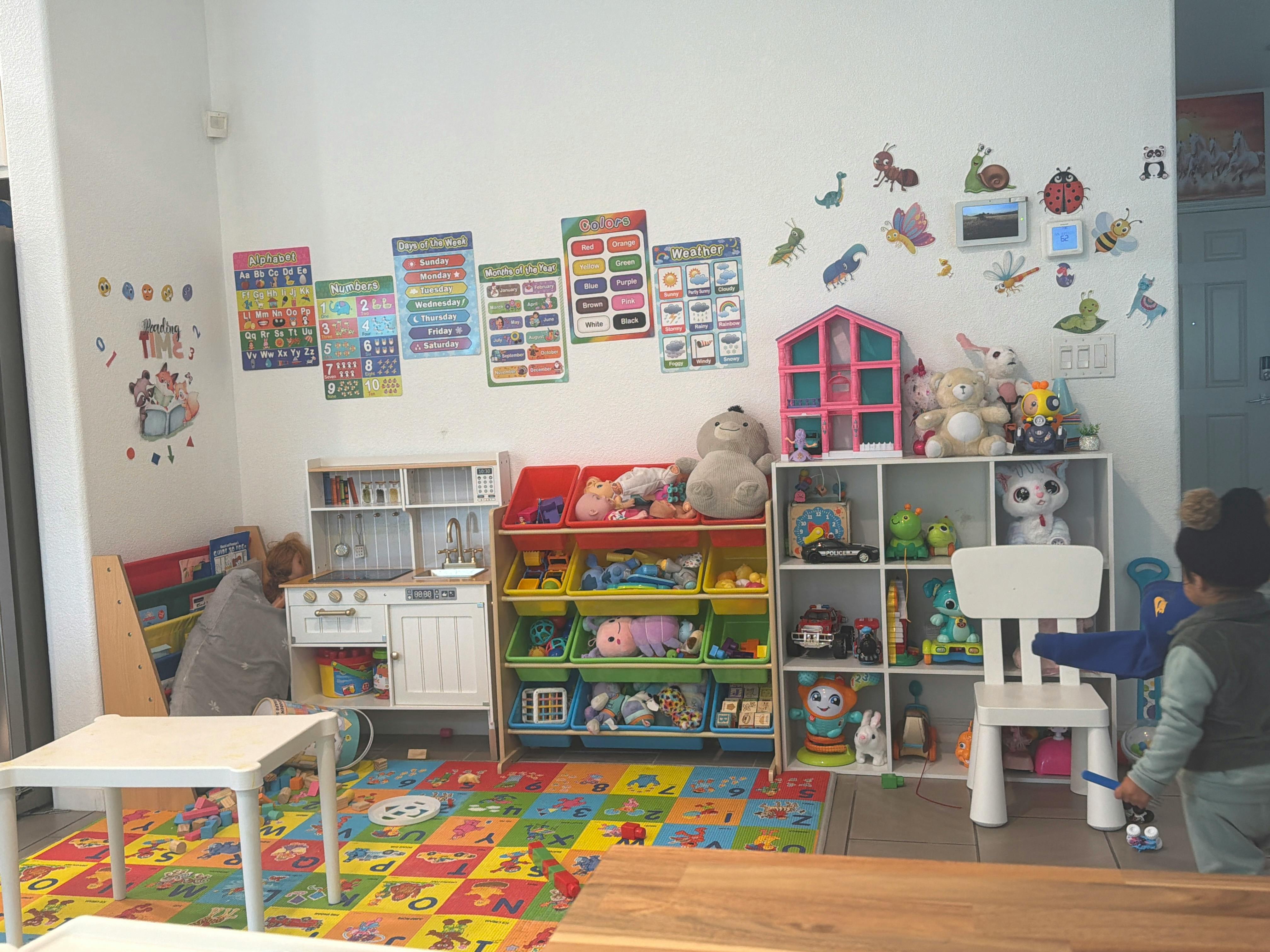 Two children playing in a room with toys and colorful rug