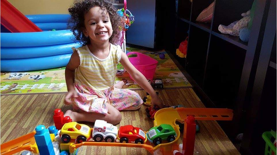 Child playing with toy cars on a track