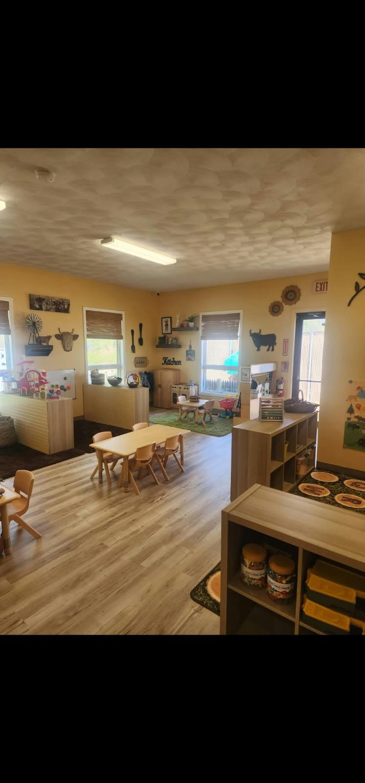 Classroom with small tables and wooden shelves