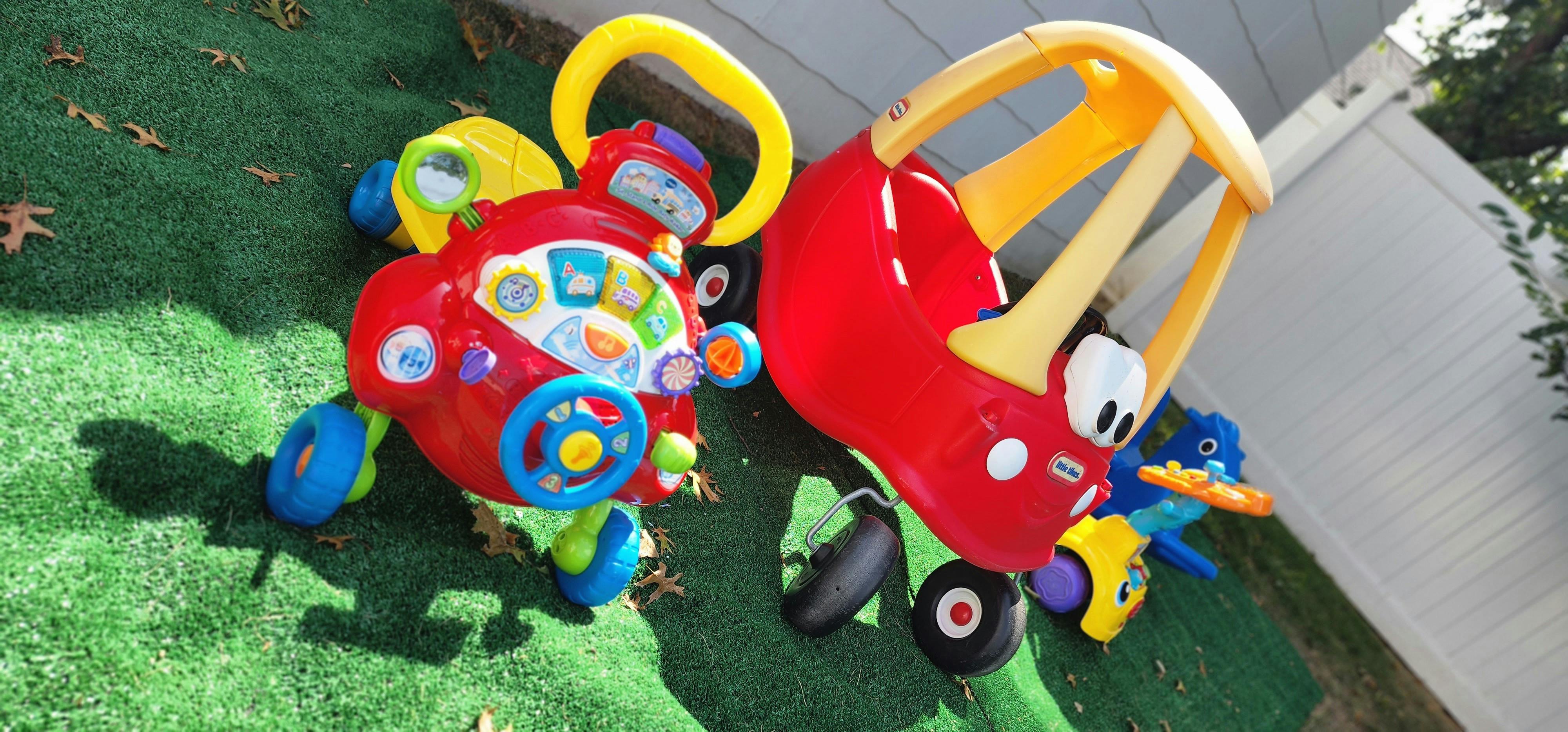 Two colorful plastic ride-on toys on green grass