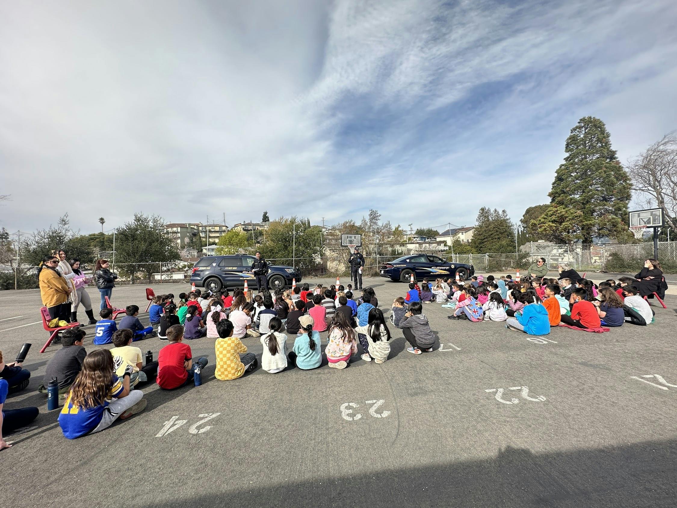 Group of children sitting on pavement outdoors
