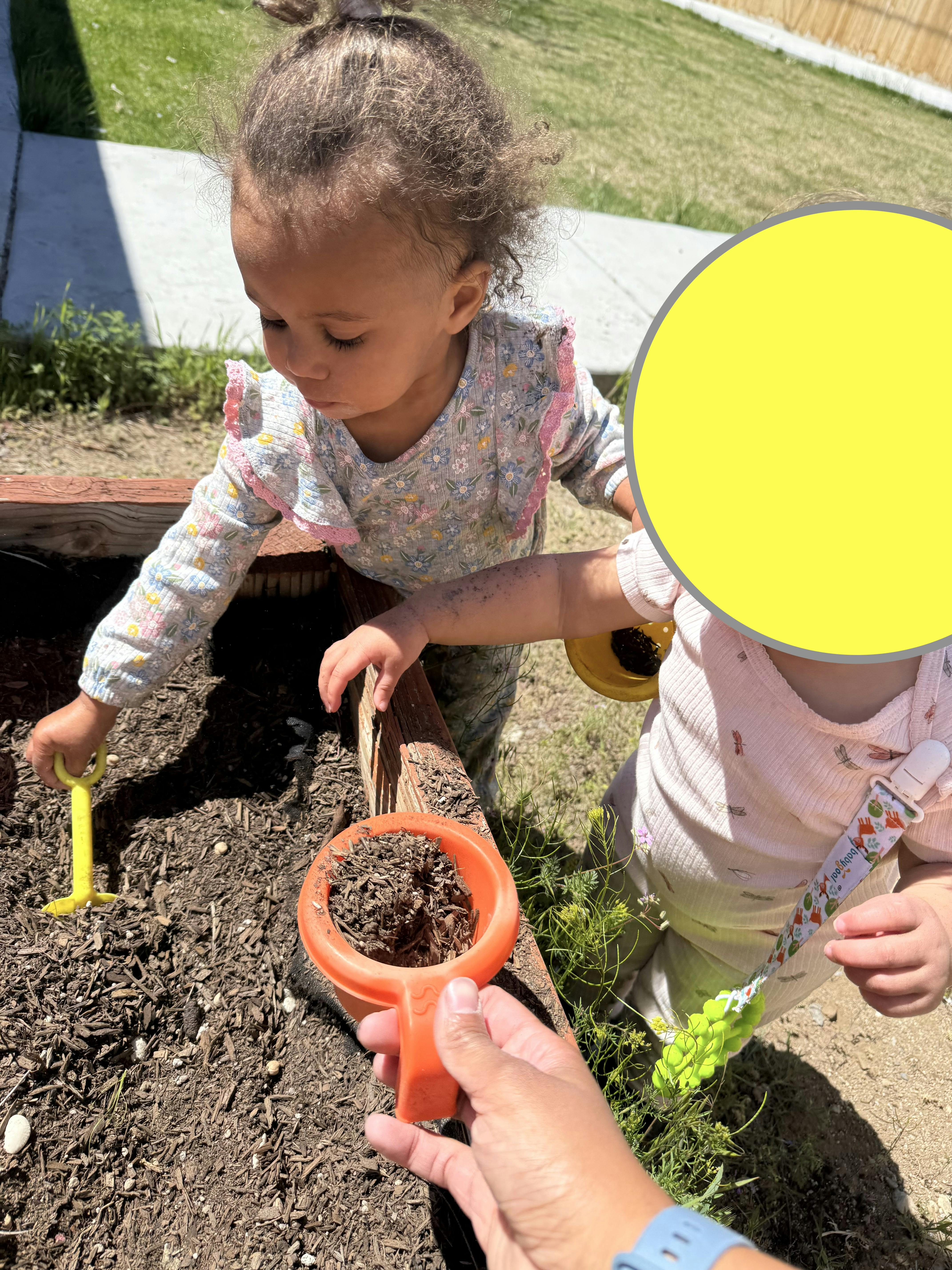 Child playing in dirt with gardening tools