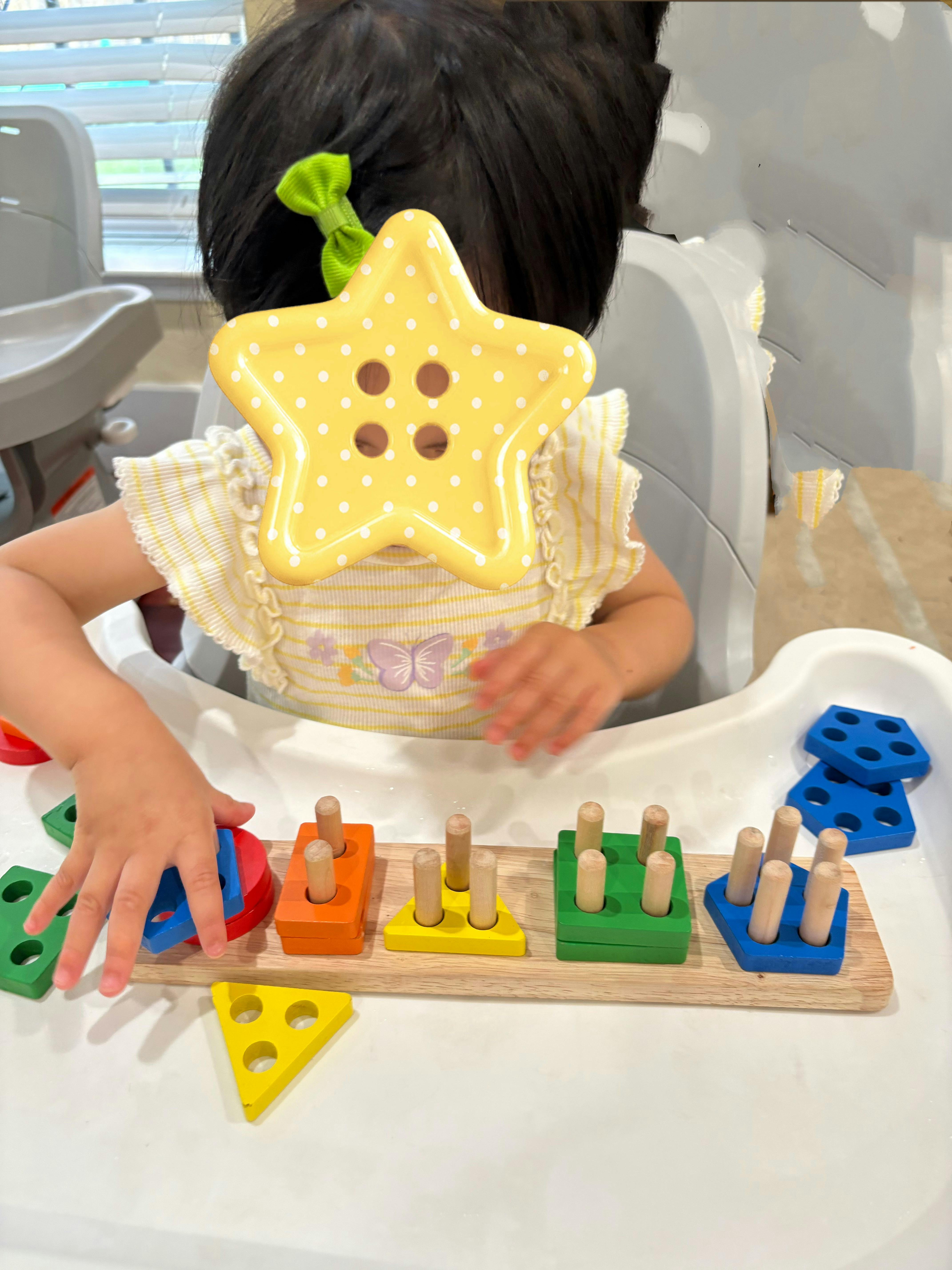 Child playing with a wooden geometric shape sorting toy