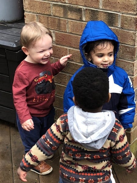 Three children standing together outdoors
