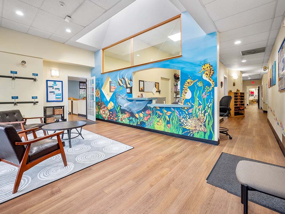 Lobby with a large ocean-themed mural and a long hallway