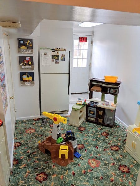Playroom with toy kitchen, toy construction site, and refrigerator