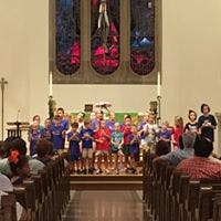 Children and adults on a stage in a church