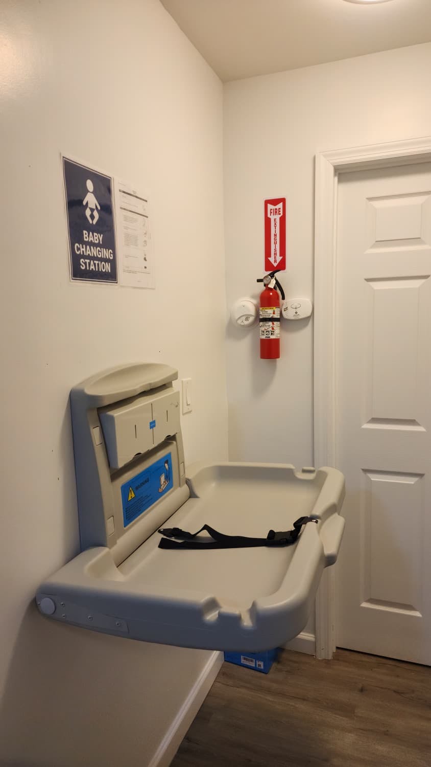 Baby changing station with a fire extinguisher on the wall