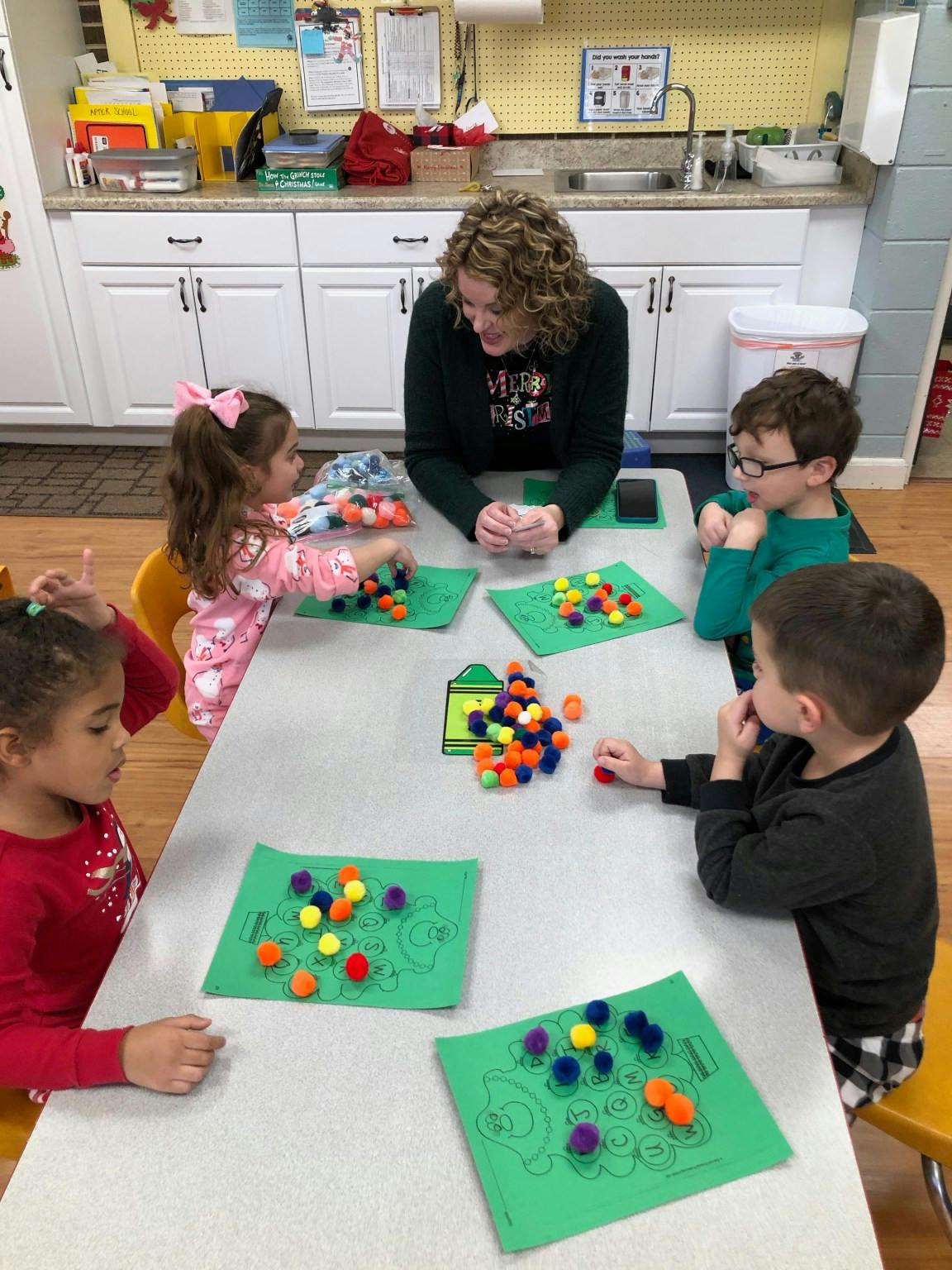 Adult and four children at a table with craft supplies