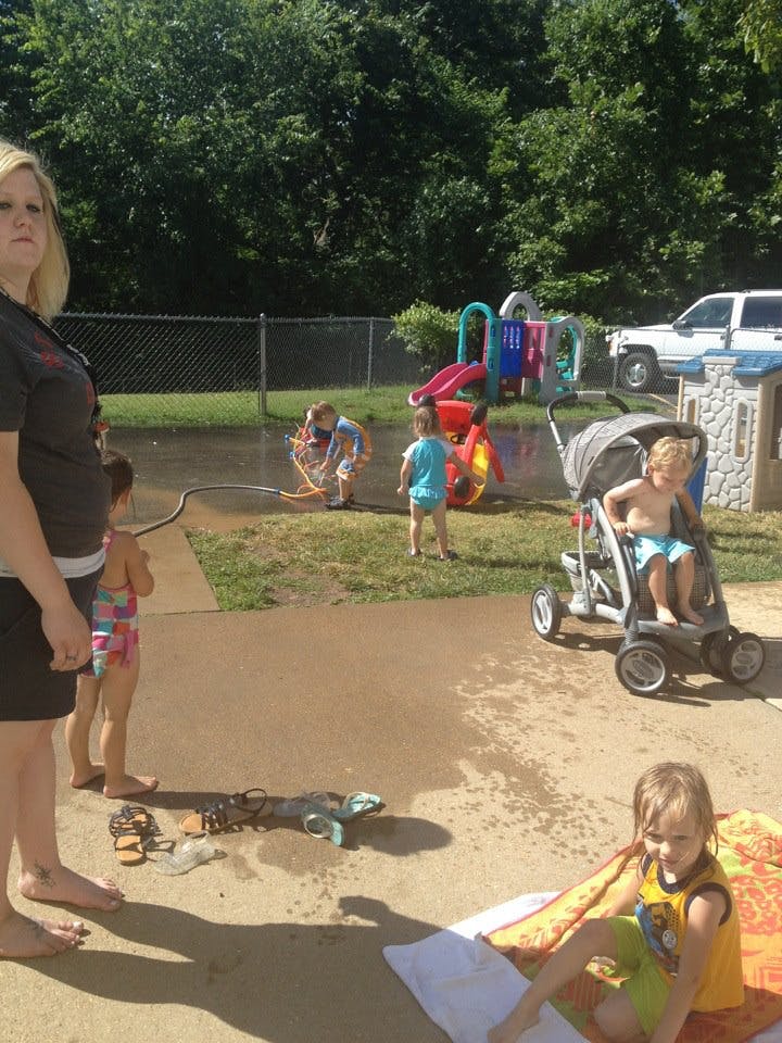 Person and children playing with water outdoors