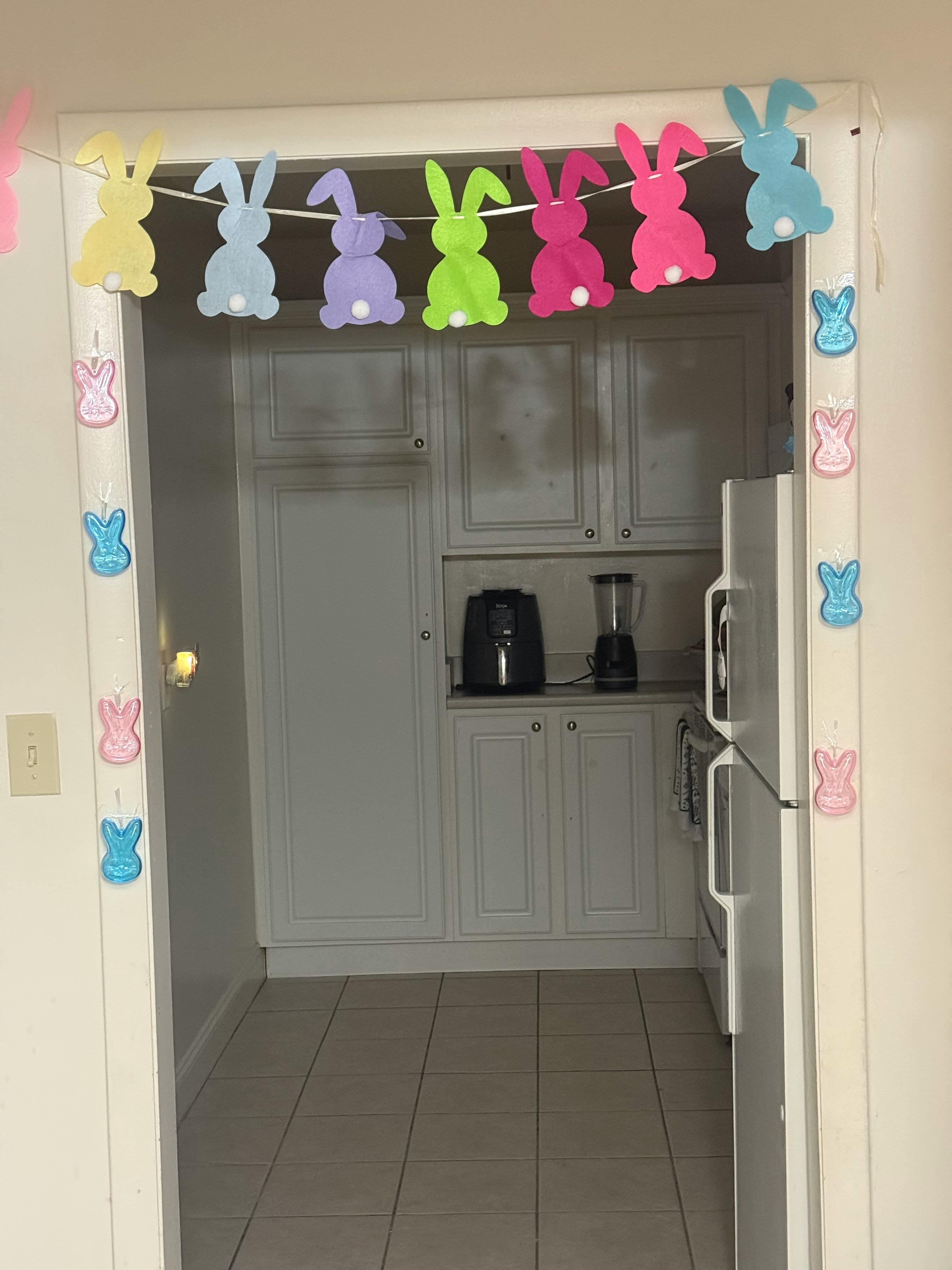 Bunny garland hanging in a doorway leading to a kitchen