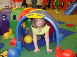 Child crawling through a play tunnel