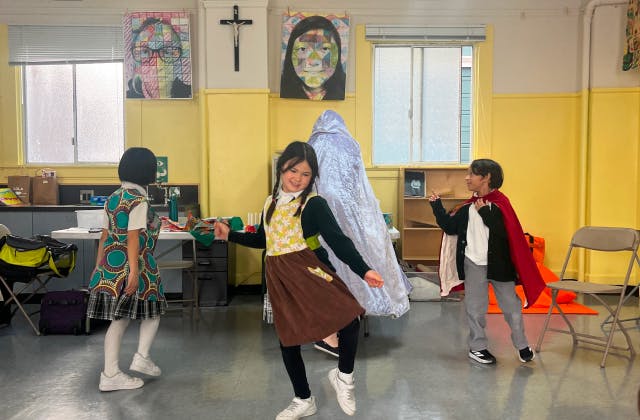 Three children in costumes playing in a room