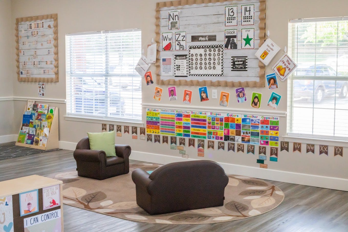 Classroom interior with small armchairs on a rug and educational wall charts
