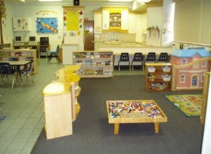 Preschool classroom with tables, chairs, and toys