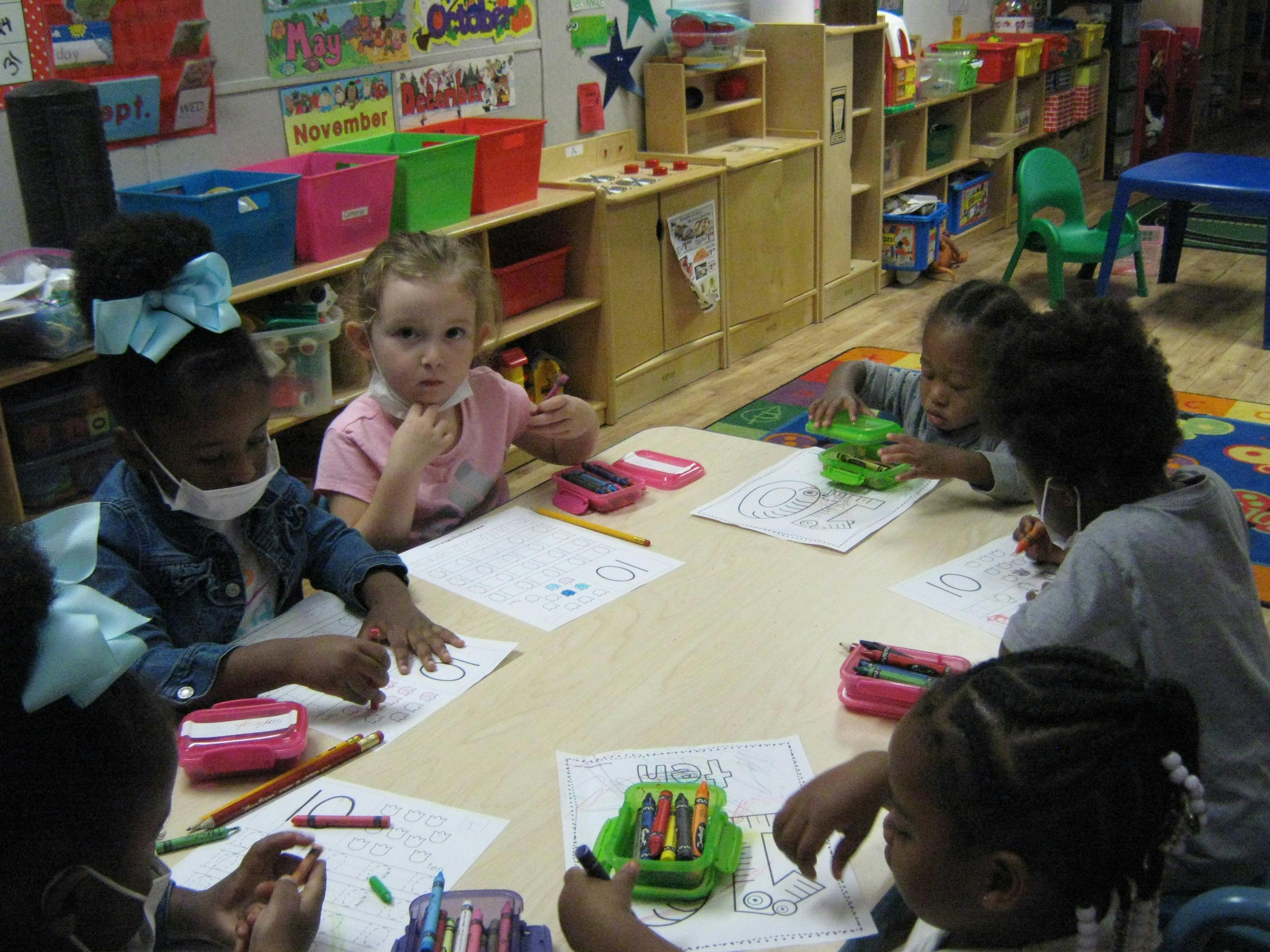 Children drawing at a table in a classroom