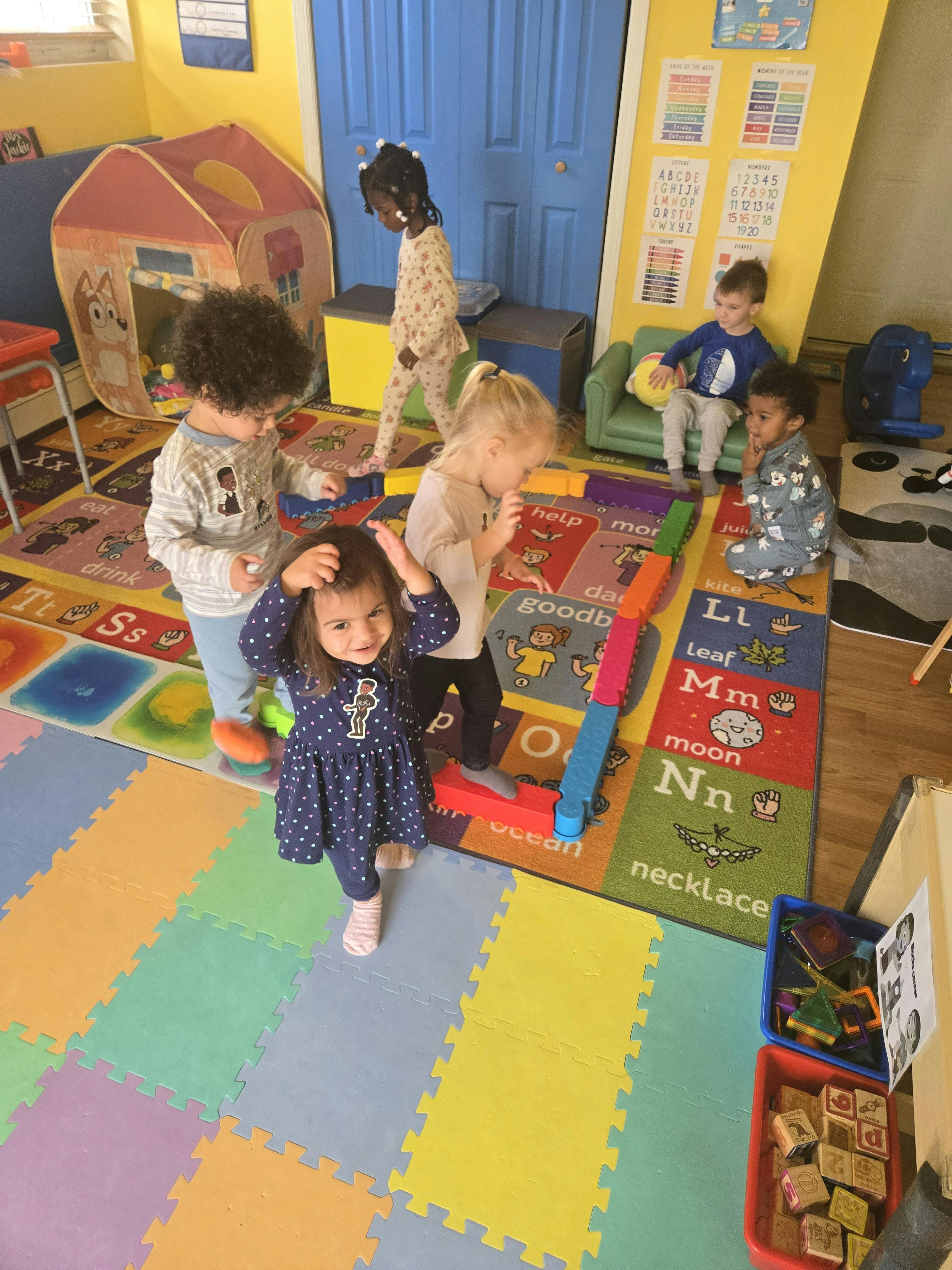 Group of children playing together in a colorful classroom
