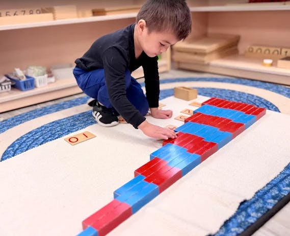 Child manipulating red and blue blocks on the floor