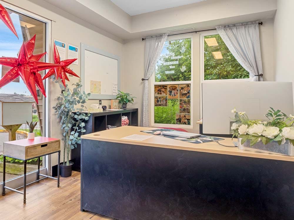 An office reception area with a desk, computer, and red star balloons
