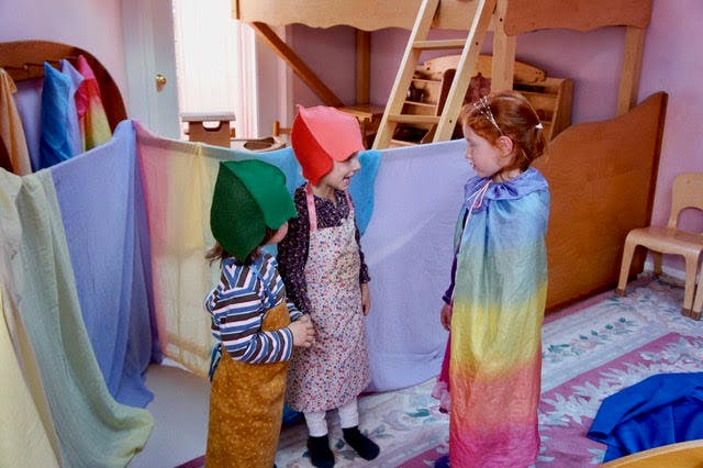 Three children playing dress-up in a room