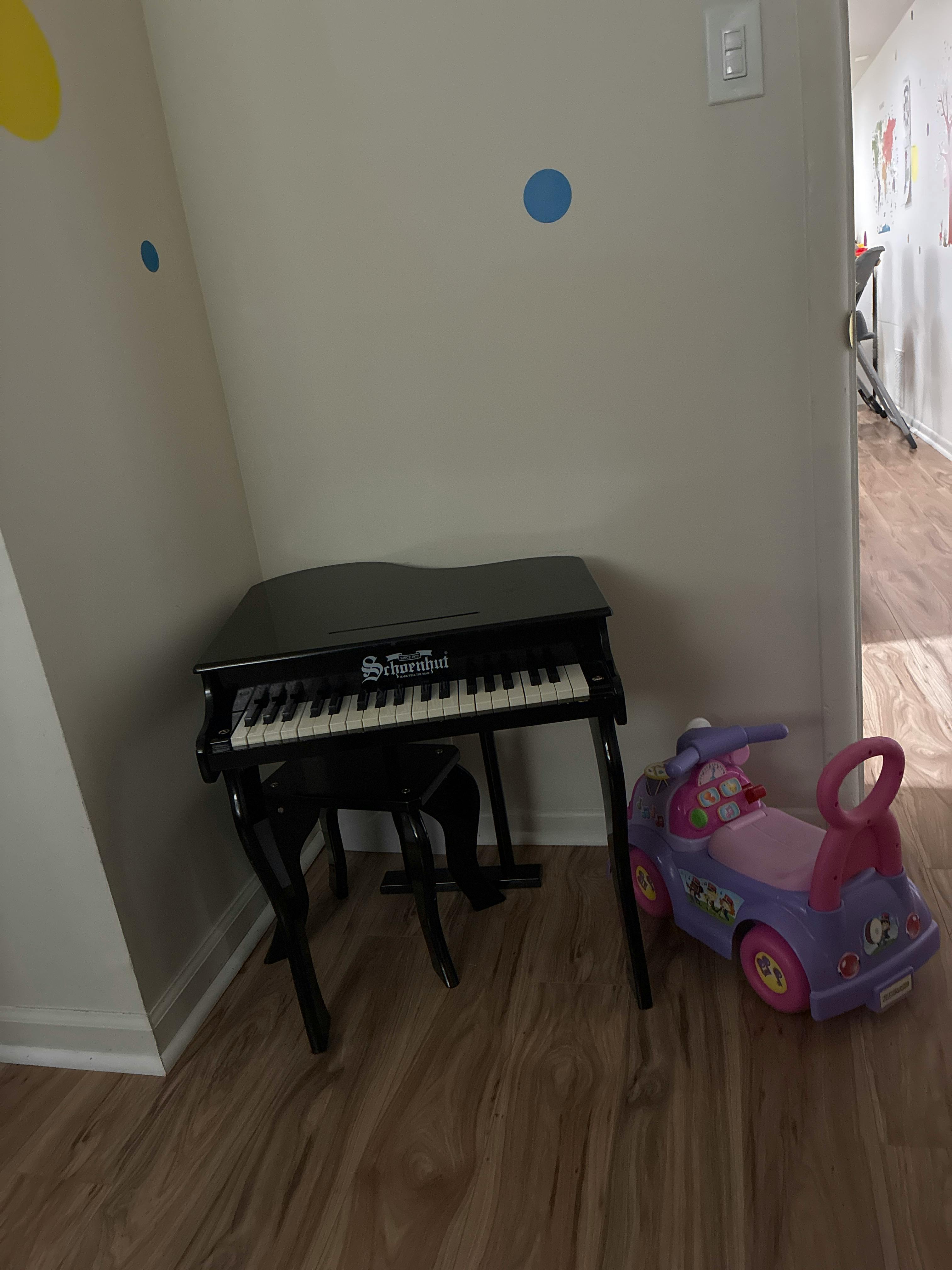 toy piano and purple toy car on wooden floor