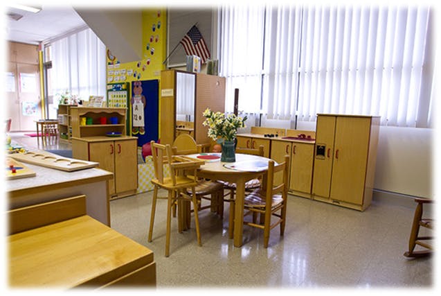 Classroom with small wooden tables and chairs