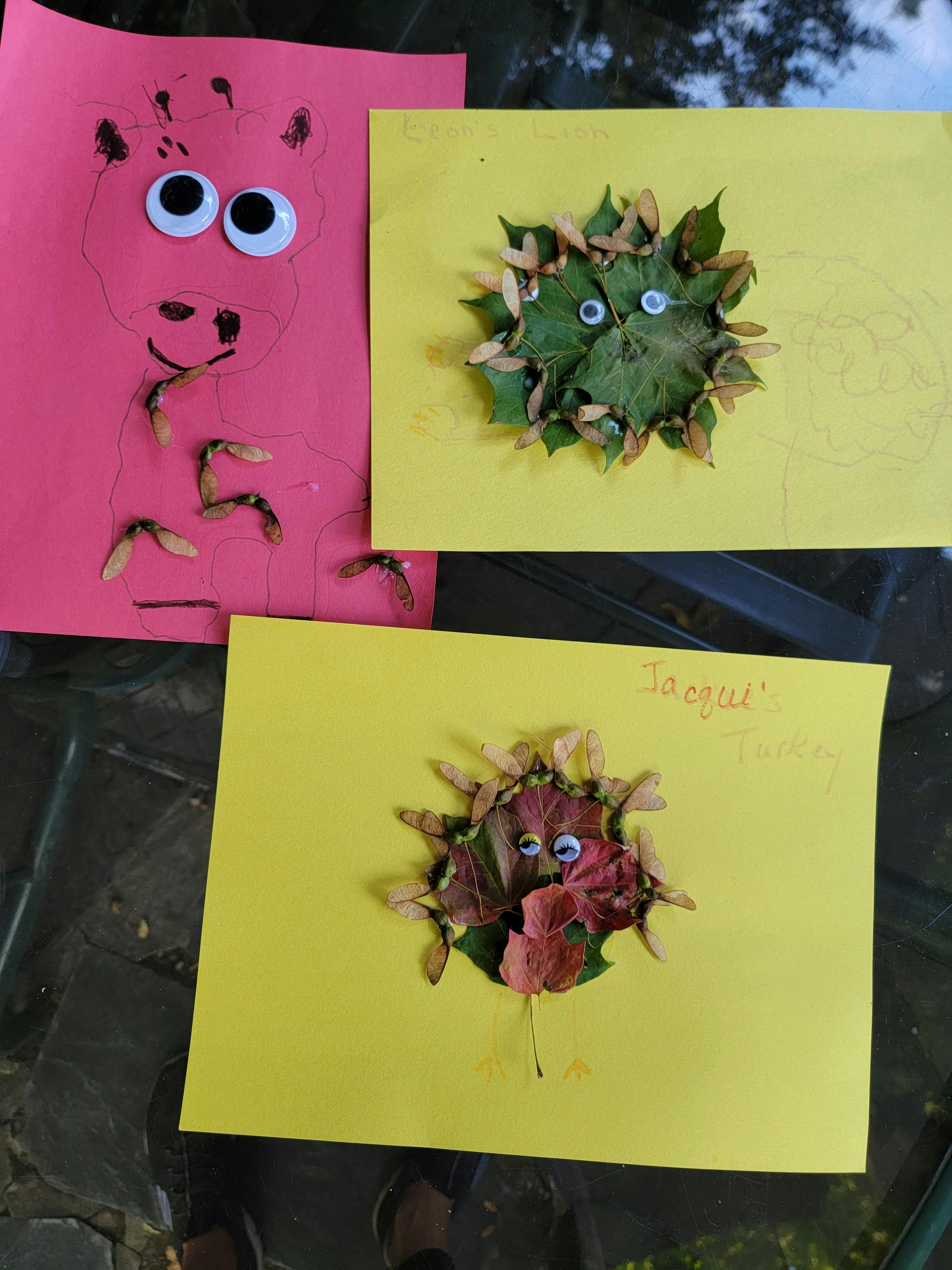 Three pieces of paper with leaf and seed art, two with googly eyes